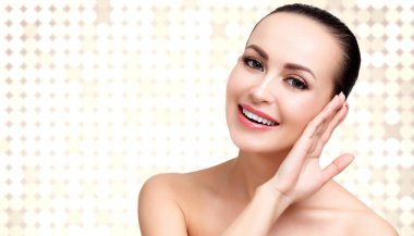 Daireler ve boşaltmak bir arka plan karşı yumuşak ve temiz bir cilt güzel kadınla poz