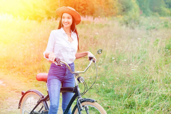 夏の公園または森林の黒い自転車を持つ女性 — ストック写真