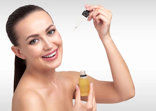 ピペットの若い女性の顔に適用する化粧品のオイルのクローズ アップ ショット 美容療法の概念 — ストック写真