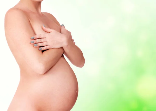 Naakte Zwangere Vrouw Poseren Tegen Een Groene Achtergrond Met Copyspace — Stockfoto