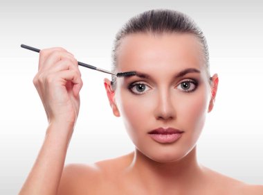 Güzel kadın ile boşaltmak gri bir arka plana dayanır. Makyaj fırça ile güzel kız closeup çekim