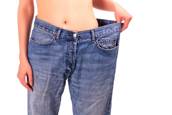 Giovane donna in jeans blu concetto di perdita di peso, isolato su sfondo bianco — Foto Stock