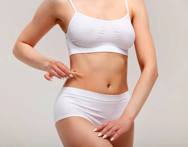 Woman pinches fat on her belly, closeup shot — Stock Photo, Image