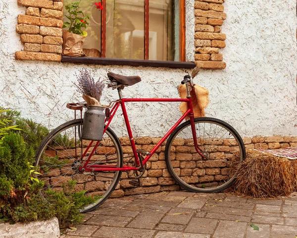 Bicicleta con flores cerca de la ventana de una vivienda —  Fotos de Stock