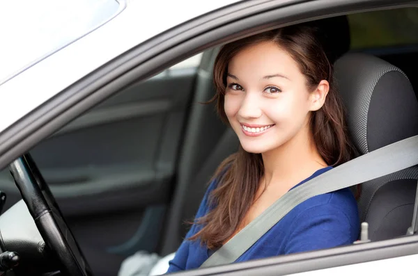 Feliz dueño de un coche nuevo. Mujer bonita conductor sonriendo a usted desde su automóvil — Foto de Stock