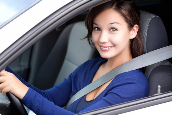Lycklig ägare till en ny bil. Pretty kvinna förare leende till dig från hennes bil — Stockfoto