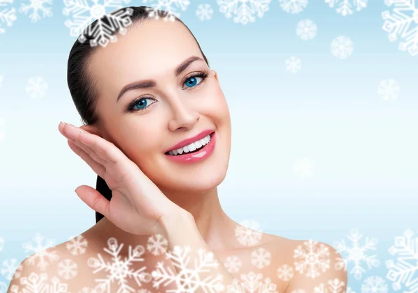 Pretty woman against a light blue background with white snowflakes — Stock Photo, Image