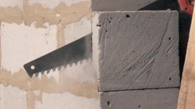 Birisi bir kapı yapmak için beton duvar kesmek için bir demir testeresi kullanır