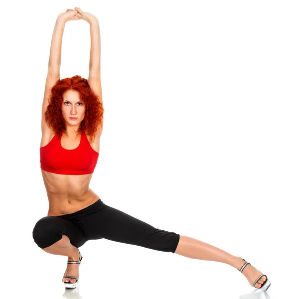 Молодая рыжая женщина делает гимнастические упражнения на белой изолированной — стоковое фото