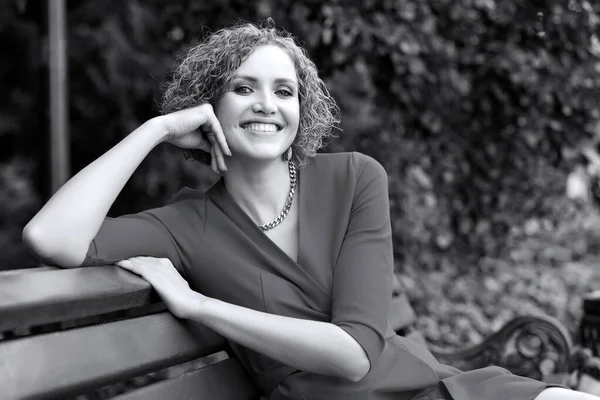 Mulher Feliz Vestido Está Sentado Banco Parque Sorrindo Para Você — Fotografia de Stock