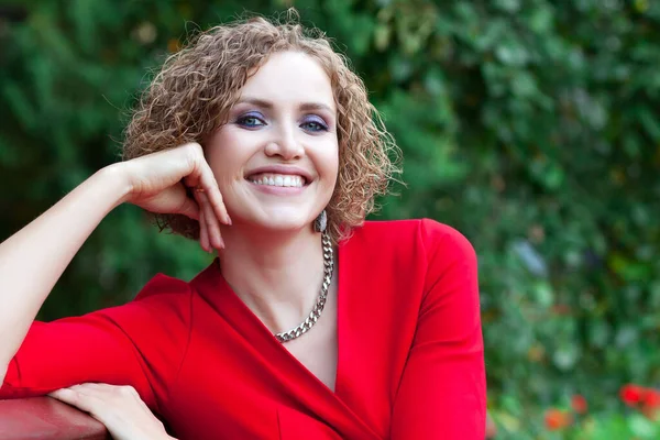 Mulher Feliz Vestido Vermelho Está Sentado Banco Parque Sorrindo Para — Fotografia de Stock