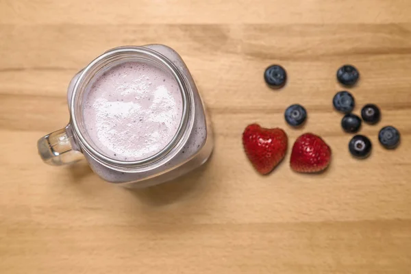 Smoothie aux baies dans un bocal maçon aux fraises et aux bleuets — Photo