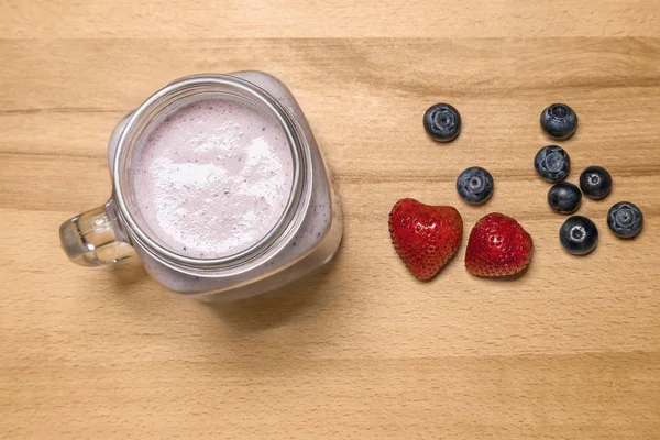 Smoothie aux baies dans un bocal maçon aux fraises et aux bleuets — Photo