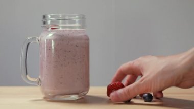 Berry güler yüzlü. Bölüm 05. Ağır çekim. Bir kadın meyveleri berry smoothies koyar.