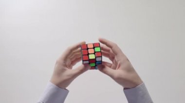 İşadamı çözme bulmaca eller. Bulmaca küp, puzzle oyunu, en çok satan oyuncak. Adamın elinde bir gömlek gülümsemek. Bölüm 01.