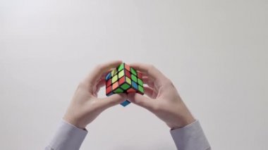 İşadamı çözme bulmaca eller. Bulmaca küp, puzzle oyunu, en çok satan oyuncak. Adamın elinde bir gömlek gülümsemek. Bölüm 04. Ağır çekim. Geri dönüştürülmüş video.
