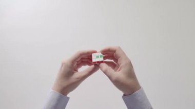 İşadamı çözme bulmaca oyuncak eller. Bulmaca küp, puzzle oyunu, en çok satan oyuncak. Adamın elinde bir gömlek gülümsemek. Bölüm 02. Hız yukarıya.