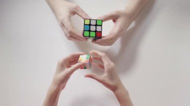 Adamın ve çocuğun elleri Rubik küpü çözme bulmaca. Bulmaca küp, puzzle oyunu, en çok satan oyuncak. Adamın ve çocuğun elleri portre. Bölüm 01. Geri dönüştürülmüş video.