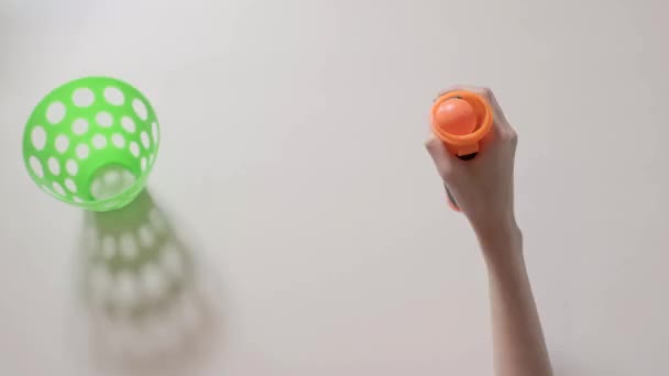 Руки Ребенка Играют Стрелковой Игрушкой Оранжевым Мячом Зеленой Корзиной Детские — стоковое видео