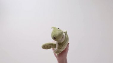 Çocuk bir yumuşak yeşil kaplumbağa oyuncakla oynar. Part_08. Çocuğun el oyuncak closeup ile.