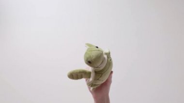 Çocuk bir yumuşak yeşil kaplumbağa oyuncakla oynar. Part_09. Çocuğun el oyuncak closeup ile.