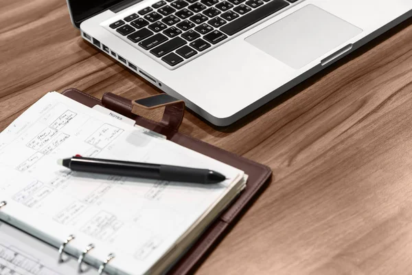 Office Masaüstü. Masanın üzerinde bir dizüstü bilgisayar, bir defter ile notlar ve tükenmez kalem olduğunu.