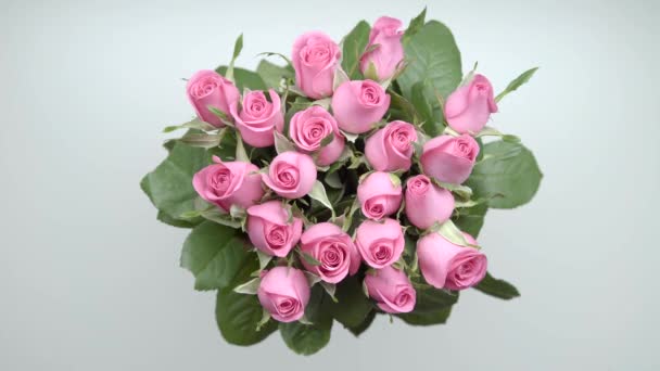 Les mains des femmes prennent bouquet de roses roses et cadeaux de la table. 25 ans 