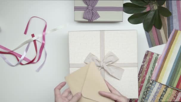 Verpackung Geschenk Einer Schachtel Mit Postkarte — Stockvideo