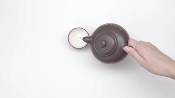 女性的手在中国杯子里倒茶 从水壶在白色的背景 慢动作 第24部分 — 图库视频影像