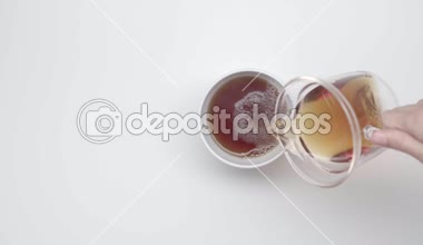 Eller bir çay cam çaydanlık üzerinden Çin Kupası beyaz zemin üzerine dökün. Çay töreni. Bölüm 42.