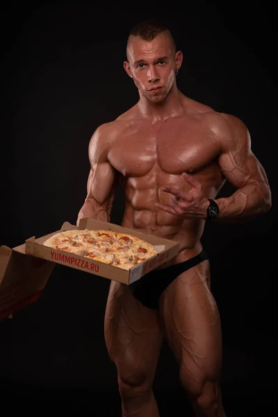 Без рубашки спортсмен с пиццей — стоковое фото