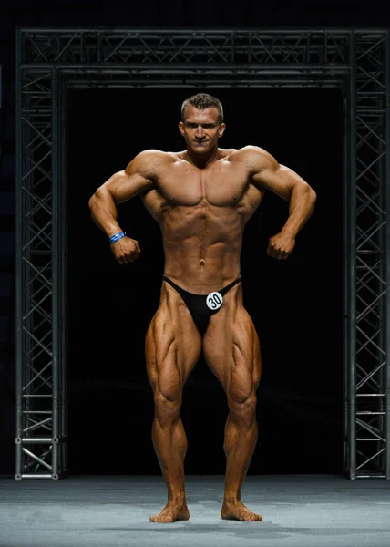 Bodybuilder masculin fléchit ses muscles — Photo