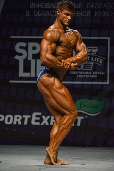 Male bodybuilder flexes his muscles — Stock Photo, Image