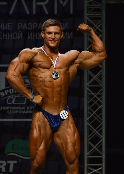 Male bodybuilder flexes his muscles — Stock Photo, Image