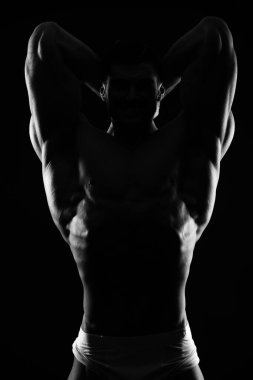 Siyah arka planda güçlü bir adamın karanlık silüeti.