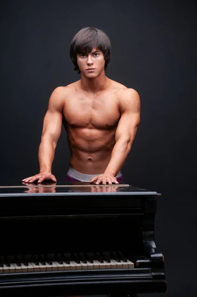 フィットネス男性モデルでスタジオでピアノ — ストック写真