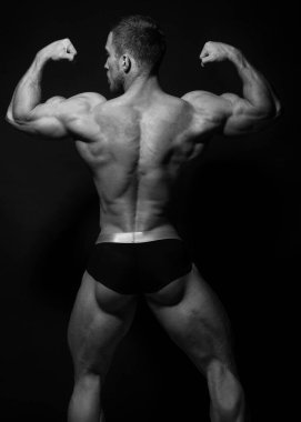 Sırtını gösteren kaslı erkek model.