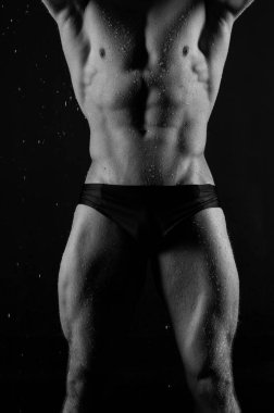 Su damlalı kaslı erkek model.