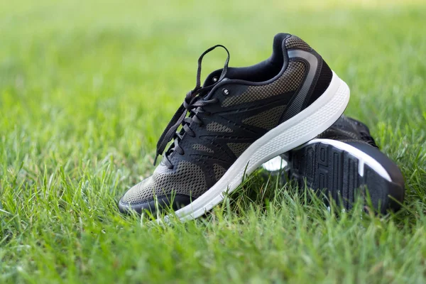 Par de zapatos deportivos de hombre en el campo verde — Foto de Stock