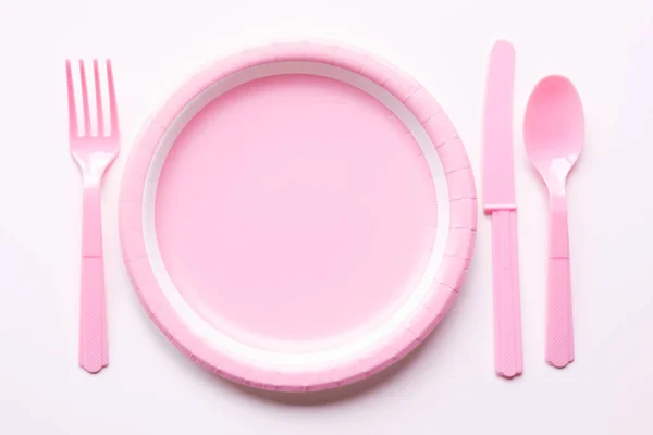 Pink color paper plate with plastic spoon, fork and knife — Stock Photo, Image