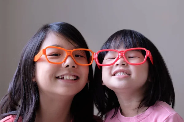 Dos hermanas pequeñas con anteojos grandes —  Fotos de Stock