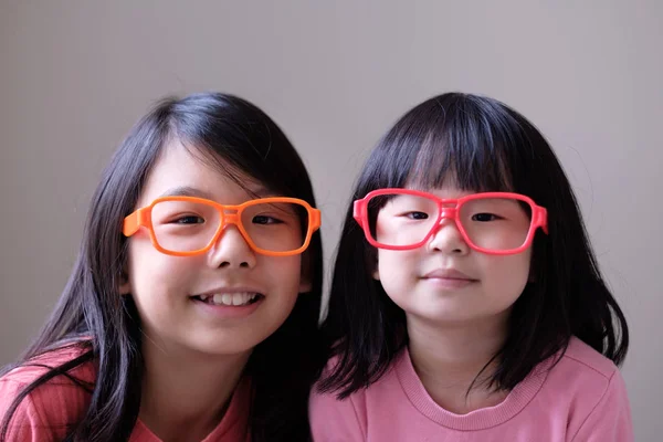 Две маленькие сестры в больших очках — стоковое фото