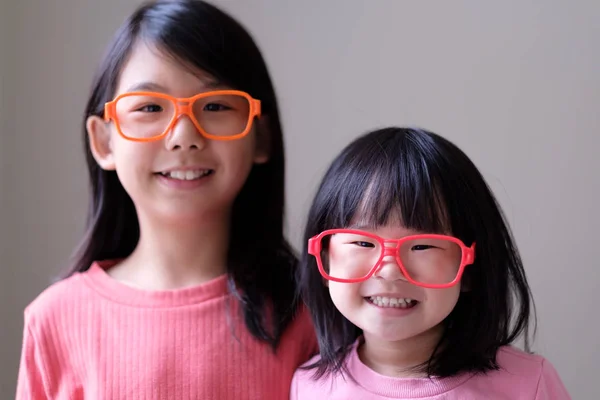 Zwei kleine Schwestern mit großer Brille — Stockfoto