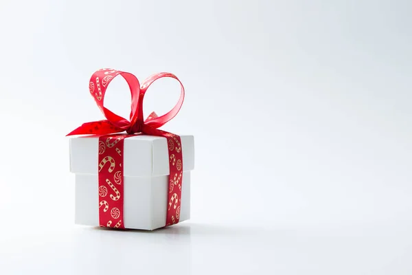 Kırmızı bir Noel Tema kurdele ile bağlanmış beyaz hediye kutusu — Stok fotoğraf