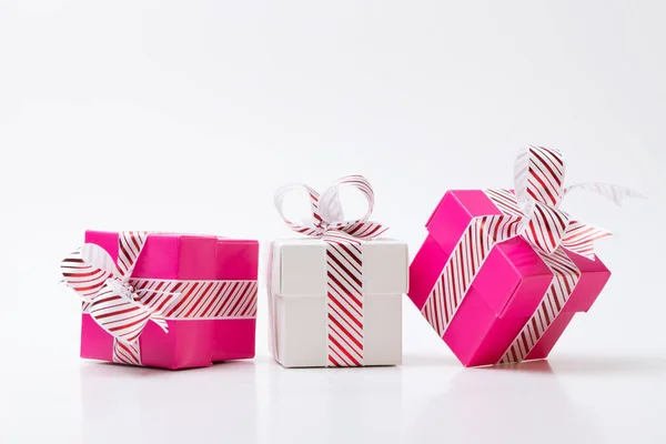 Caixas de presente rosa e branco amarrado com faixa vermelha branca fita — Fotografia de Stock