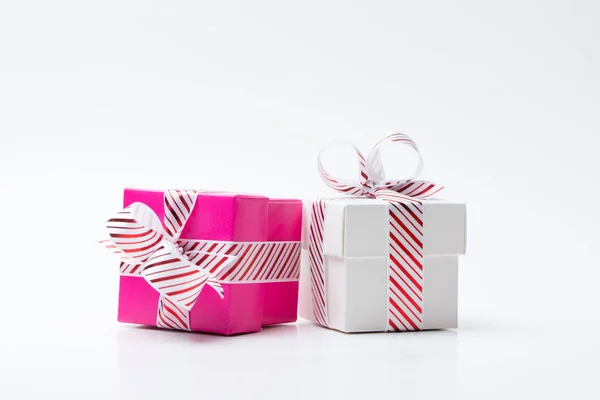 Scatola regalo rosa e bianca legata con nastro bianco a strisce rosse — Foto Stock