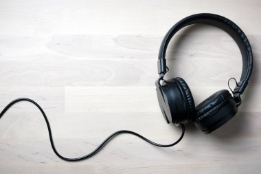 Ahşap arka plan üzerinde izole siyah kulaklık