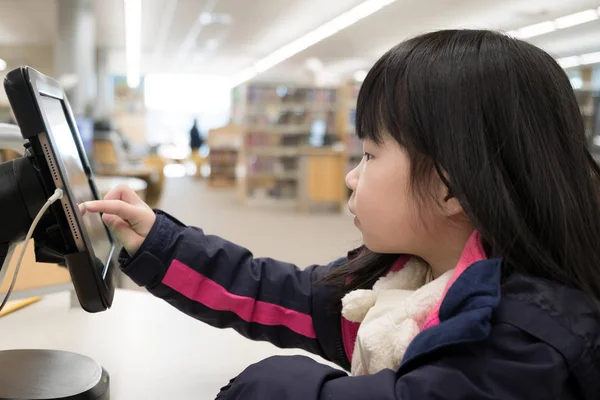 Niño usando tableta digital en la biblioteca — Foto de Stock