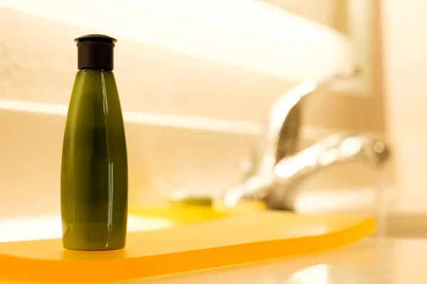 Petit récipient de shampooing vert dans la salle de bain — Photo