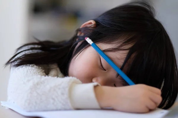 Asiatico giovane bambino si addormenta durante lo studio — Foto Stock